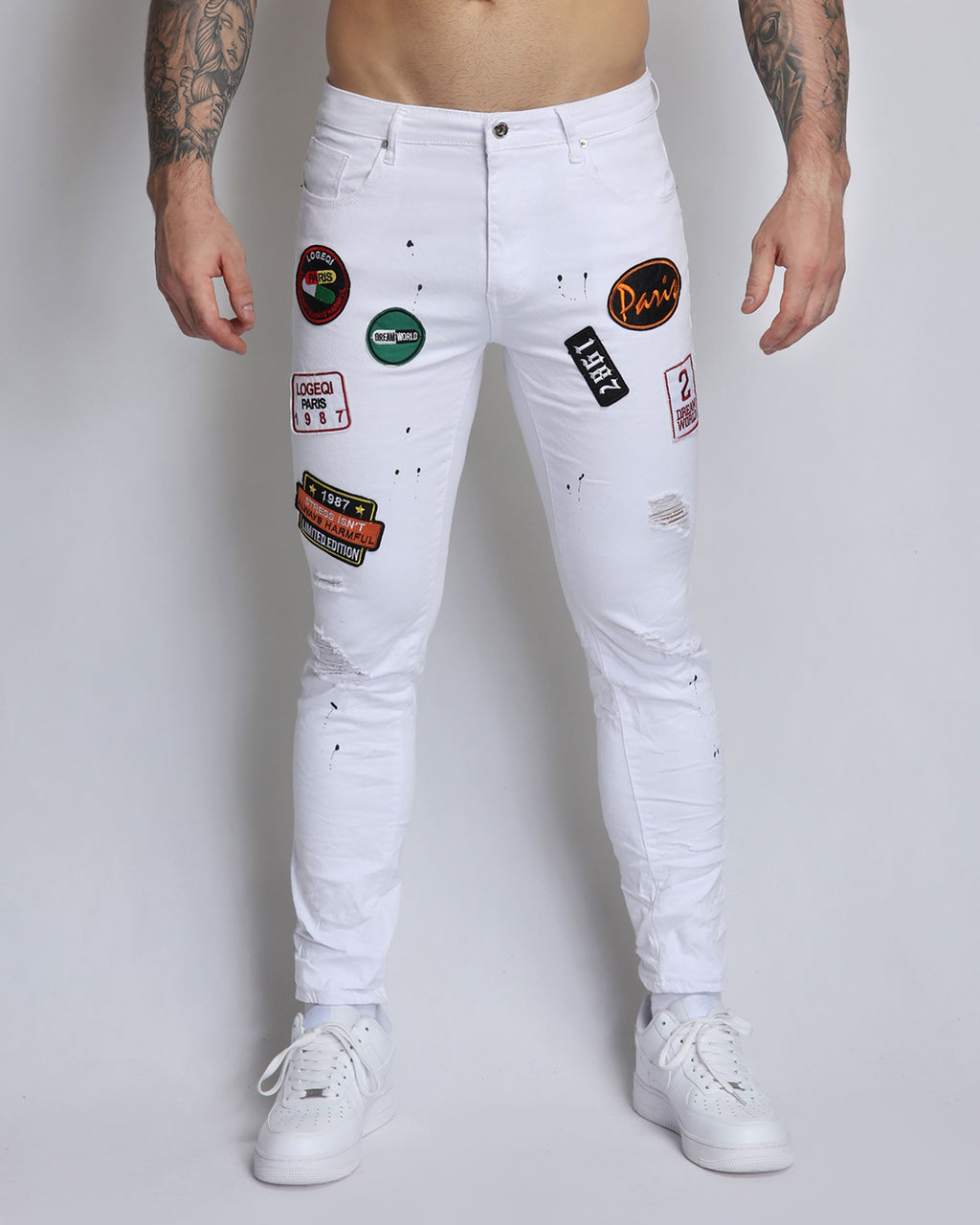 White Ripped Jeans with Badge and Black Spray Paint